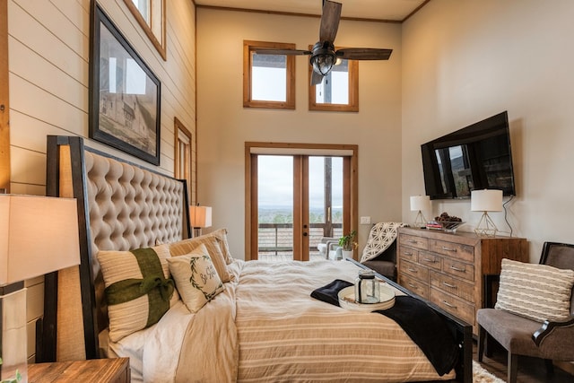 bedroom featuring french doors, a high ceiling, and wooden walls