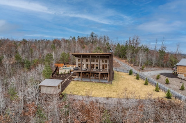 back of house with a deck, a fenced backyard, a lawn, a patio, and a wooded view