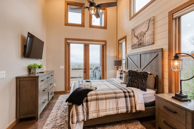 bedroom featuring a high ceiling, dark wood finished floors, access to exterior, french doors, and baseboards