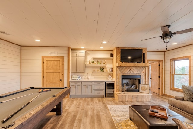 game room featuring wood walls, wine cooler, wooden ceiling, a sink, and light wood finished floors