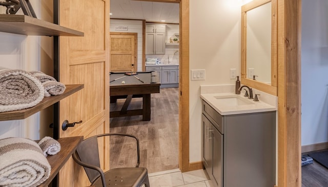 bathroom featuring recessed lighting, a sink, baseboards, and backsplash
