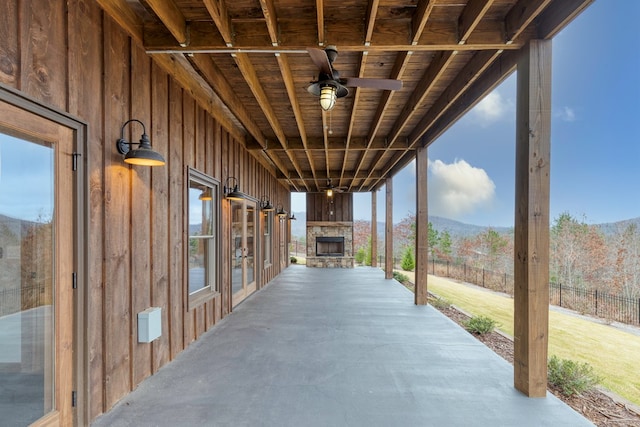 view of patio with fence, a ceiling fan, and a mountain view