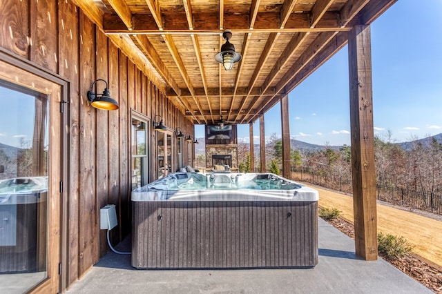 view of patio featuring a hot tub, central AC unit, and a mountain view