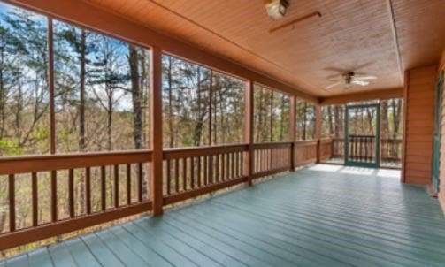 unfurnished sunroom with wooden ceiling and a ceiling fan