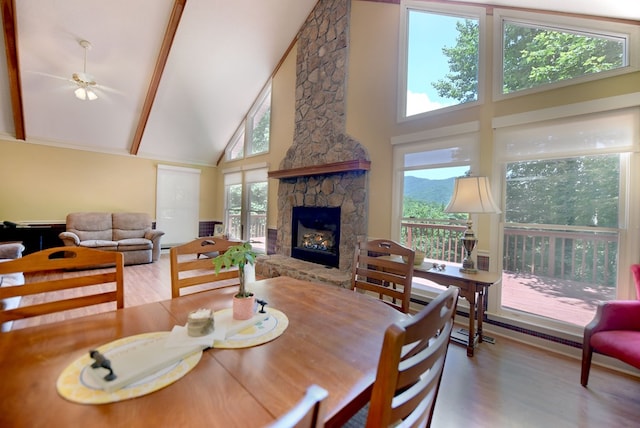 8300 Soapstone Creek Cir, Hiawassee, GA 30546 - dining space featuring high vaulted ceiling, a stone fireplace, wood finished floors, and beamed ceiling
