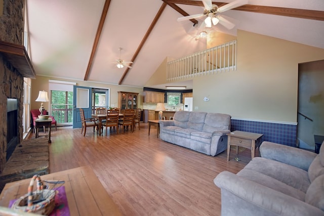 8300 Soapstone Creek Cir, Hiawassee, GA 30546 - living room with a ceiling fan, high vaulted ceiling, light wood finished floors, beamed ceiling, and a stone fireplace