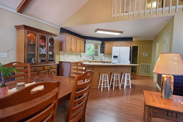 8300 Soapstone Creek Cir, Hiawassee, GA 30546 - kitchen with white appliances, wood finished floors, decorative backsplash, light countertops, and vaulted ceiling