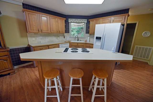 8300 Soapstone Creek Cir, Hiawassee, GA 30546 - kitchen with white appliances, wood finished floors, light countertops, a kitchen breakfast bar, and a center island