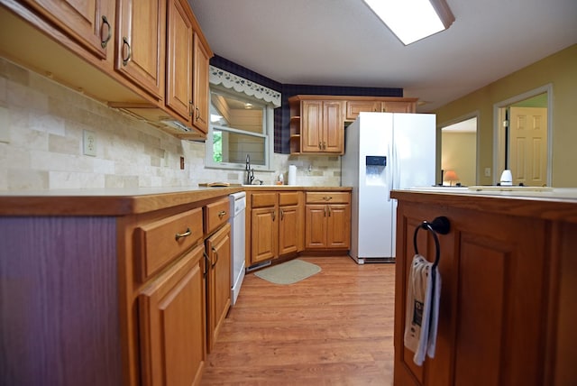 8300 Soapstone Creek Cir, Hiawassee, GA 30546 - kitchen featuring white appliances, light countertops, light wood finished floors, backsplash, and brown cabinets