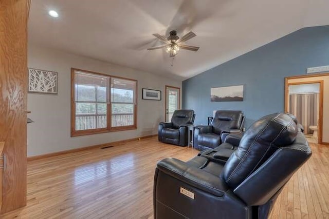 living area featuring lofted ceiling, ceiling fan, visible vents, baseboards, and light wood finished floors