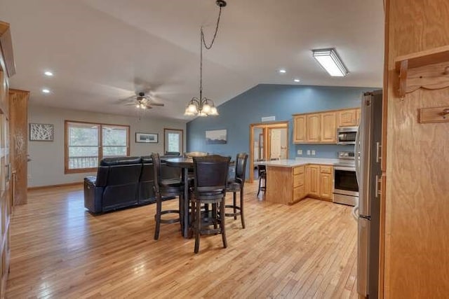 kitchen featuring light countertops, light brown cabinetry, appliances with stainless steel finishes, open floor plan, and light wood-type flooring