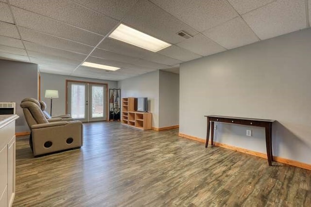 interior space featuring french doors, a drop ceiling, wood finished floors, and visible vents