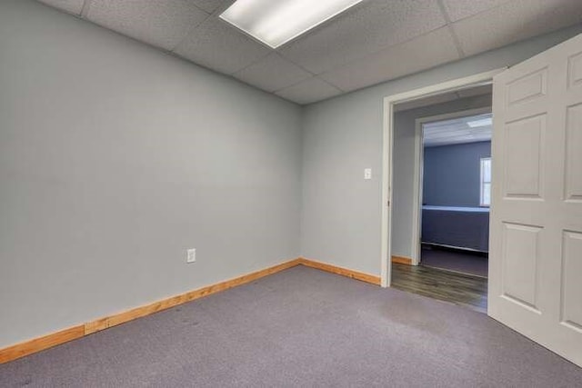 unfurnished room featuring carpet floors, baseboards, and a paneled ceiling