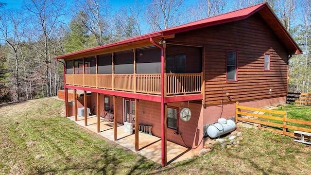 exterior space featuring a lawn, a patio, a sunroom, fence, and central AC