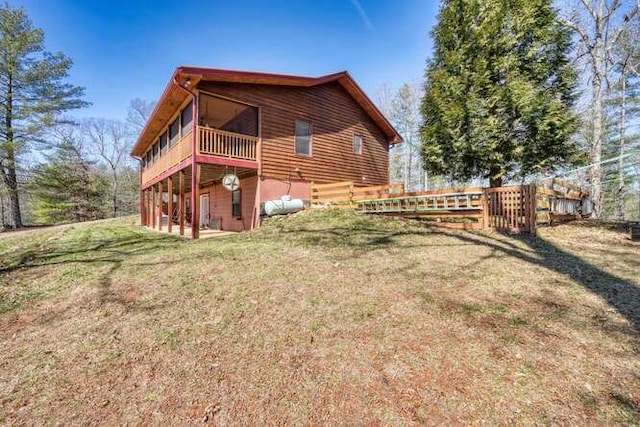 view of side of home featuring a lawn and fence