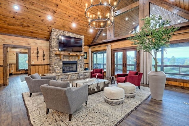 living room featuring high vaulted ceiling, wooden walls, hardwood / wood-style floors, wood ceiling, and a fireplace