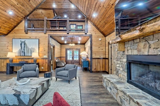 living room with hardwood / wood-style flooring, wood walls, and wooden ceiling