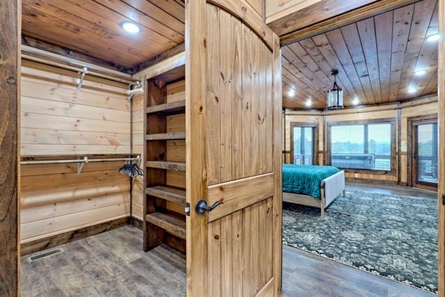 interior space with wood walls, dark hardwood / wood-style flooring, and wooden ceiling