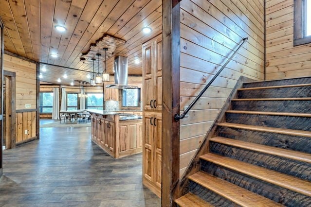 staircase featuring wood walls, wood-type flooring, and wood ceiling