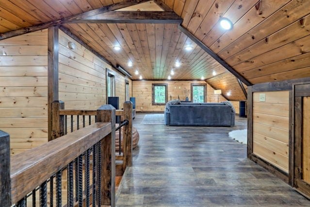 bedroom with wood ceiling, dark hardwood / wood-style floors, wood walls, and lofted ceiling with beams