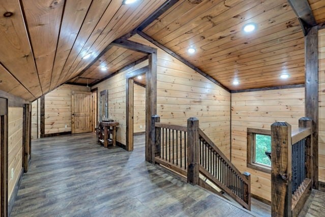 hall with vaulted ceiling, wood ceiling, wood walls, and dark hardwood / wood-style flooring