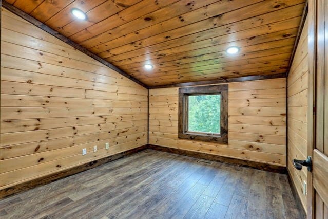 unfurnished room with dark hardwood / wood-style floors, wood walls, vaulted ceiling, and wood ceiling