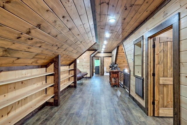 additional living space featuring wood walls, wooden ceiling, dark wood-type flooring, and vaulted ceiling