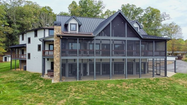 back of house with a yard, a sunroom, and a patio