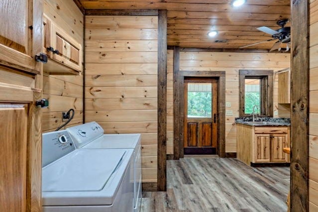 washroom featuring light hardwood / wood-style floors, ceiling fan, separate washer and dryer, wood ceiling, and wooden walls