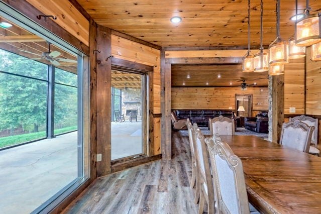 unfurnished dining area with wood walls, wooden ceiling, and wood-type flooring