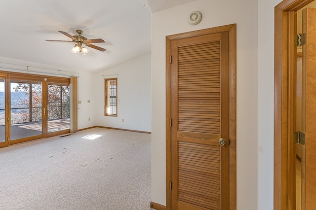 empty room with carpet, french doors, a textured ceiling, ceiling fan, and lofted ceiling