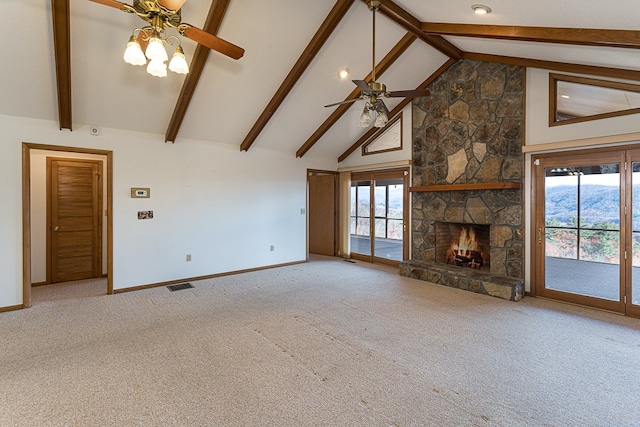 unfurnished living room with a stone fireplace, plenty of natural light, and carpet floors