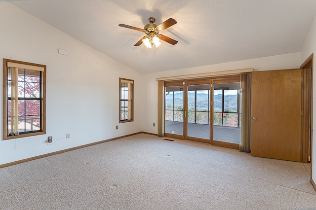 carpeted spare room with a textured ceiling, ceiling fan, and lofted ceiling