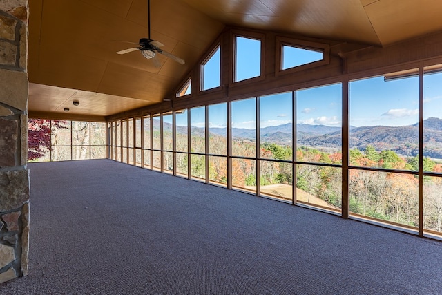 unfurnished sunroom with a mountain view, a healthy amount of sunlight, ceiling fan, and vaulted ceiling