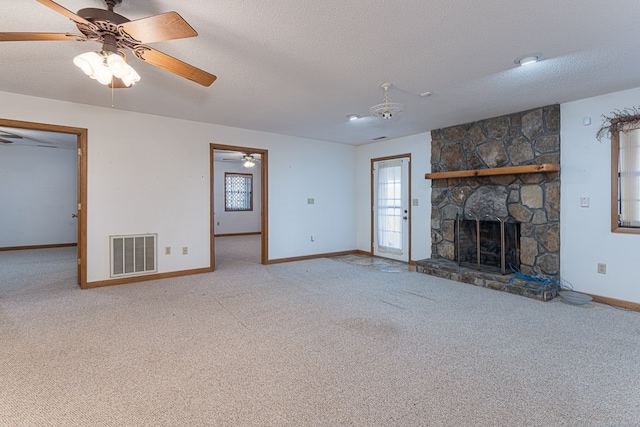 unfurnished living room with a fireplace, a textured ceiling, light colored carpet, and ceiling fan