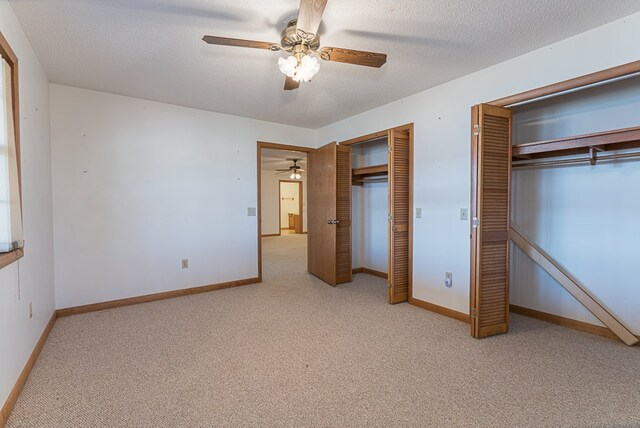 unfurnished bedroom with ceiling fan, light colored carpet, and a textured ceiling