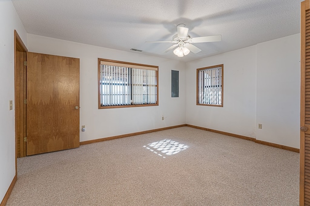 carpeted empty room with electric panel, ceiling fan, and a textured ceiling