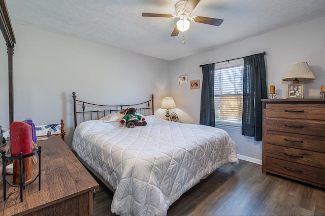 bedroom with dark wood-style floors, baseboards, and ceiling fan