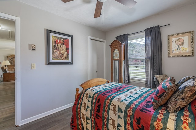 bedroom featuring dark wood finished floors, baseboards, a ceiling fan, and attic access