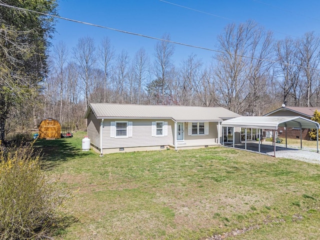 view of front of property with a carport, gravel driveway, a front yard, and metal roof