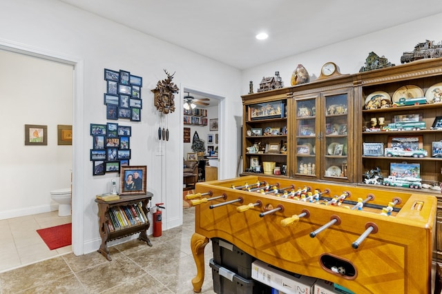 rec room with light tile patterned flooring and ceiling fan