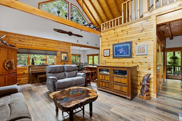 living room featuring beam ceiling, hardwood / wood-style flooring, wooden ceiling, and wood walls