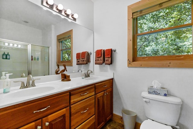 bathroom featuring vanity, toilet, and a shower with shower door