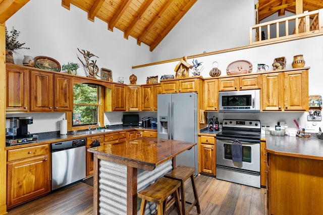 kitchen with sink, stainless steel appliances, dark wood-type flooring, wooden ceiling, and beam ceiling