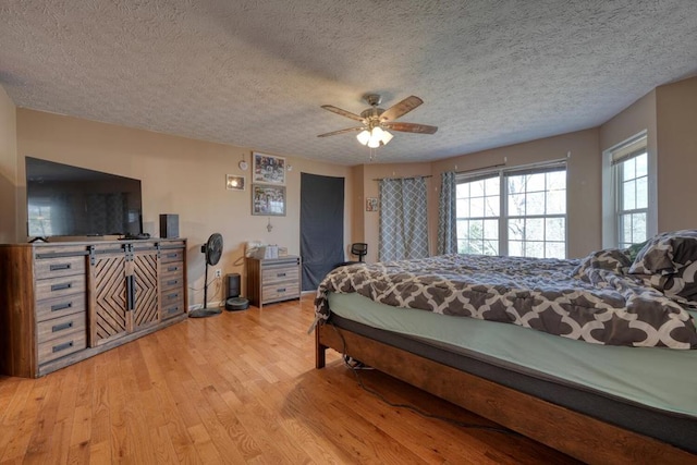 bedroom featuring a textured ceiling, ceiling fan, and light hardwood / wood-style flooring