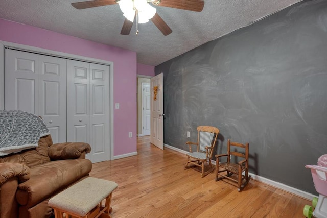 sitting room with light hardwood / wood-style floors and a textured ceiling