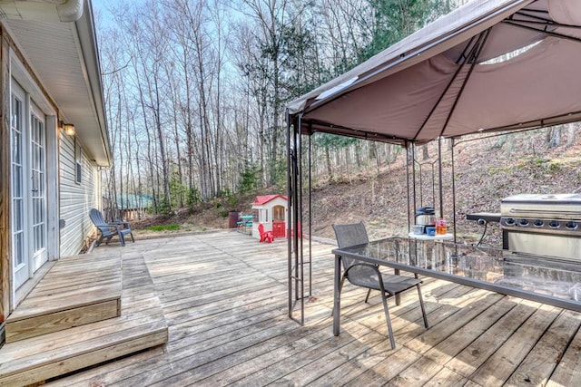 wooden deck with a gazebo and area for grilling