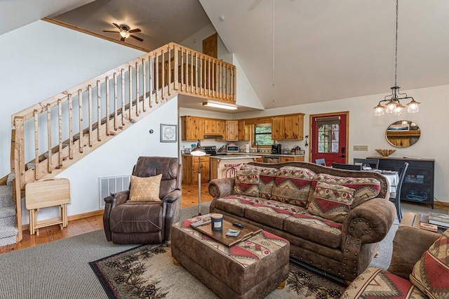40 White Cloud Dr, Murphy, NC 28906 - living room with ceiling fan, light wood-style floors, high vaulted ceiling, stairs, and a chandelier