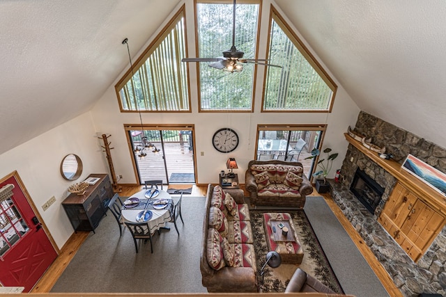 40 White Cloud Dr, Murphy, NC 28906 - living area featuring a stone fireplace, high vaulted ceiling, ceiling fan, a textured ceiling, and wood finished floors