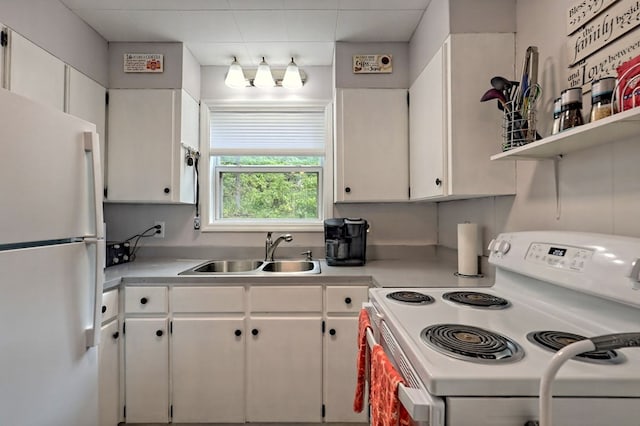 kitchen with sink, white cabinets, and white appliances